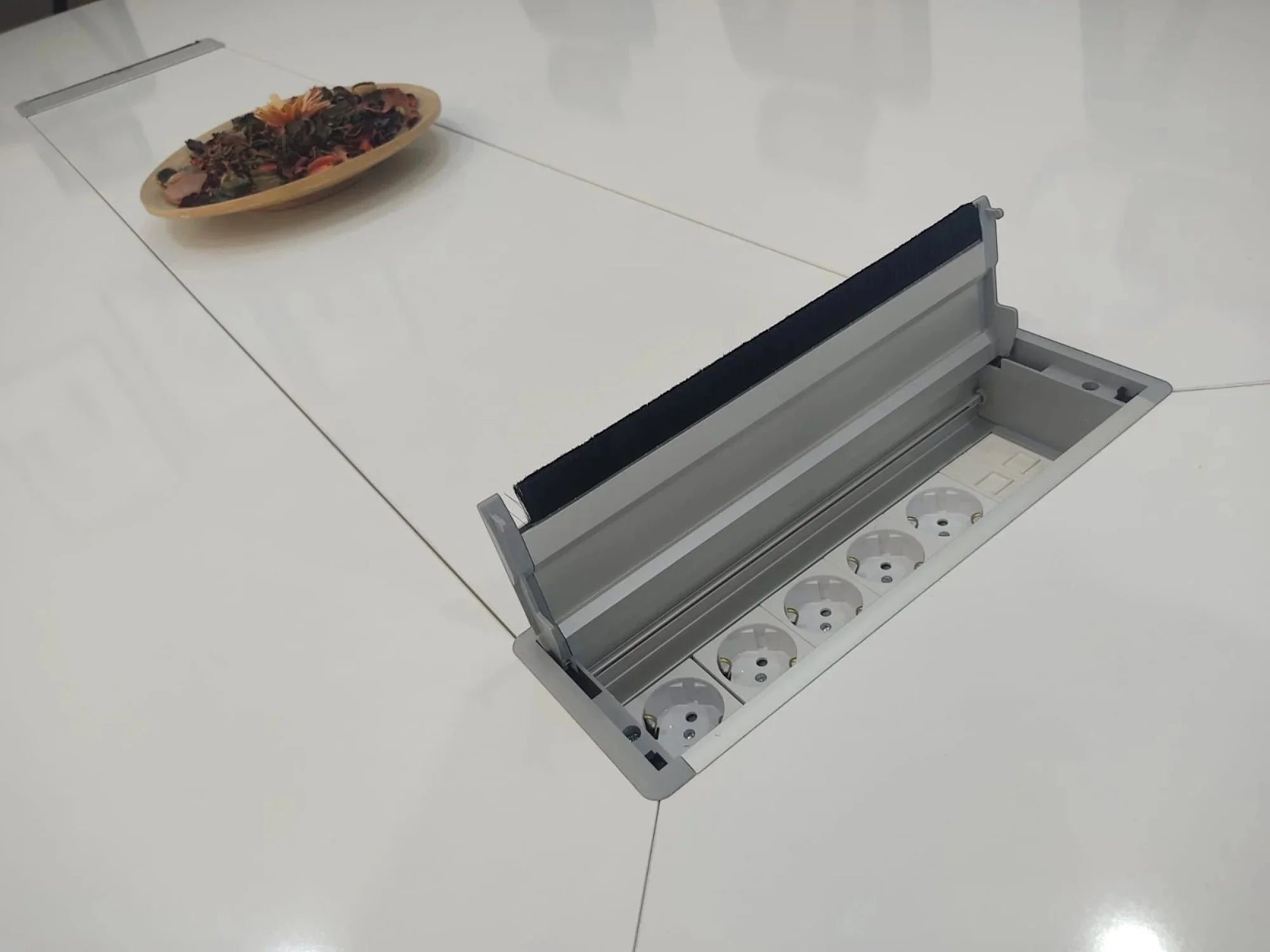 İstanbul Ofis Mobilya beyaz oval toplantı masası üzerinde entegre priz kutusu ve kablo yönetim sistemi.